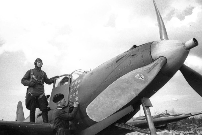 Техник-лейтенант Тонконогий Г.А. рисует очередную звездочку на своем самолете. На крыле стоит пилот истребителя мл. лейтенант Бурматов В.А.