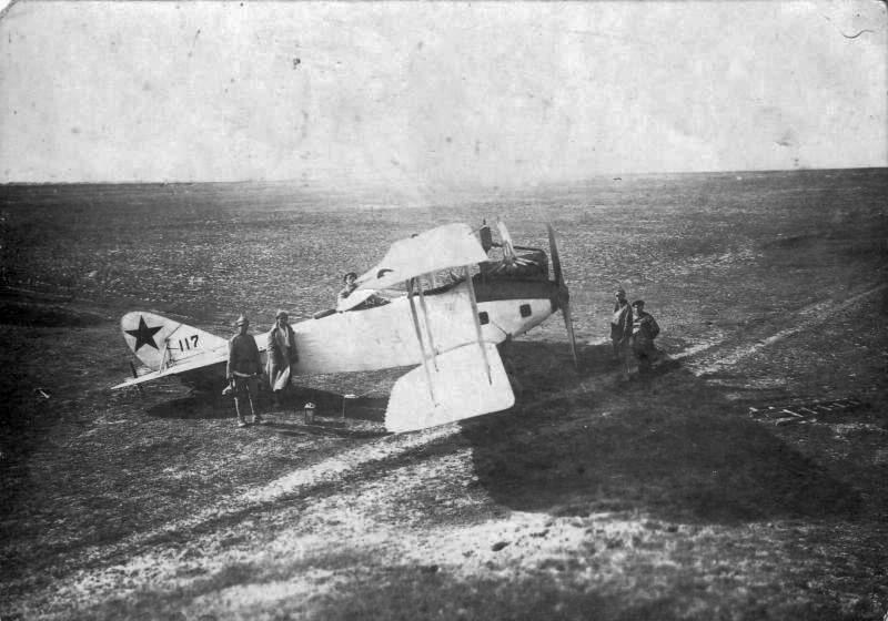 Тимашев Александр Григорьевич стоит возле самолета № 117 с группой людей (во время борьбы с басмачами в Туркестане).1919.